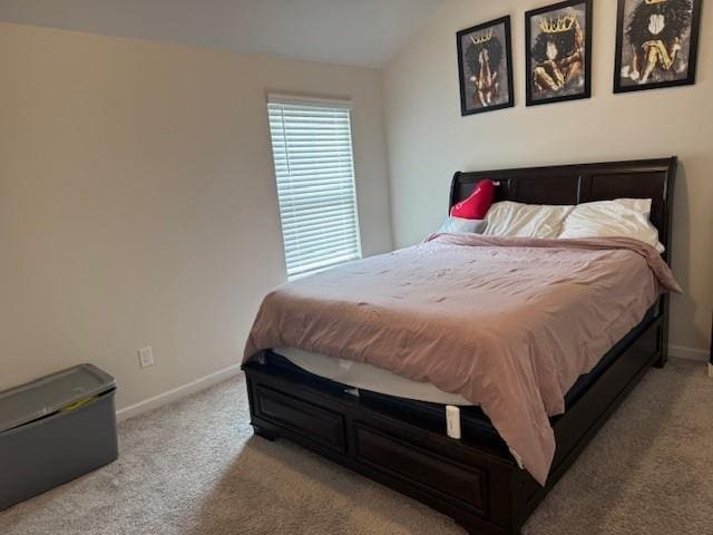 bedroom with vaulted ceiling and light carpet