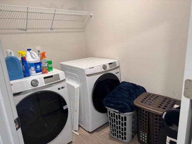 laundry room with light wood-type flooring and independent washer and dryer