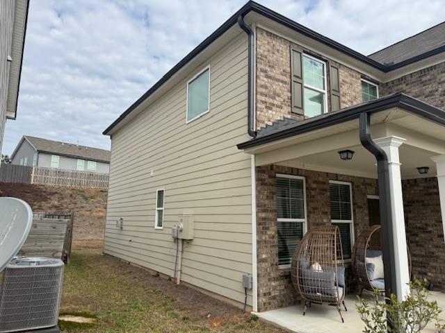 view of property exterior with central AC and a patio area