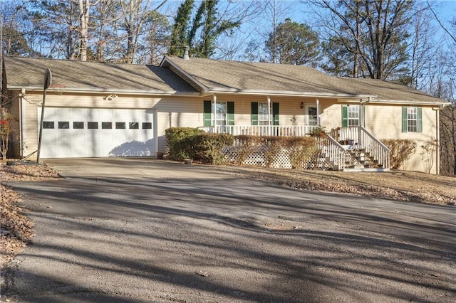 single story home featuring driveway, a porch, a chimney, and an attached garage