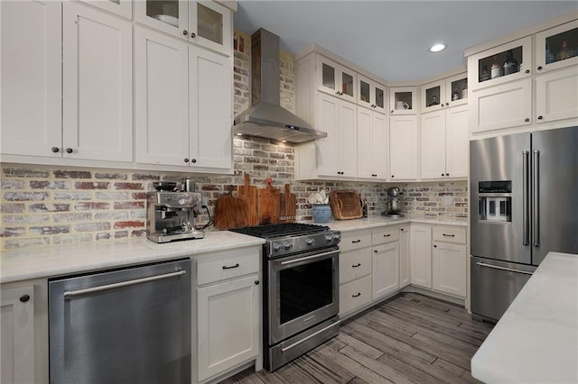 29 Highpoint Ridge Ct, Ellijay, GA 30536 - kitchen featuring decorative backsplash, appliances with stainless steel finishes, white cabinetry, wood finished floors, and wall chimney exhaust hood