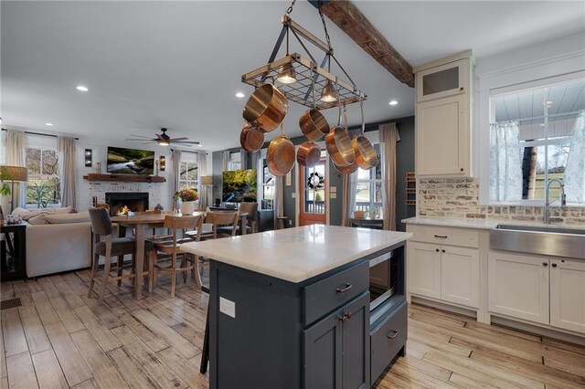 29 Highpoint Ridge Ct, Ellijay, GA 30536 - kitchen with light wood-style flooring, a sink, white cabinets, light countertops, and stainless steel microwave