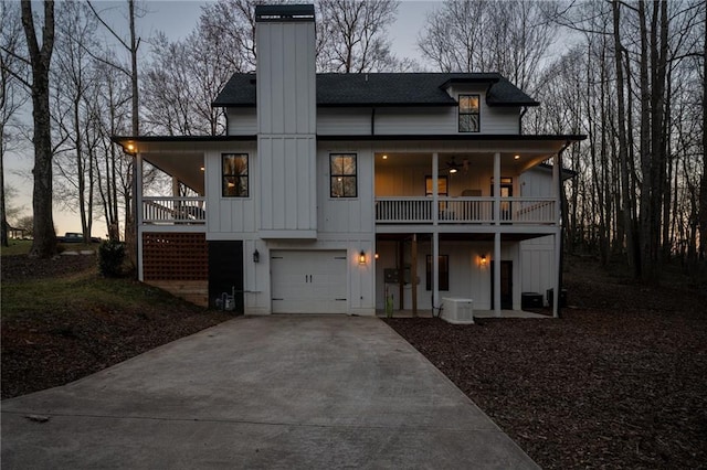 29 Highpoint Ridge Ct, Ellijay, GA 30536 - view of front facade featuring a porch, an attached garage, a shingled roof, concrete driveway, and board and batten siding