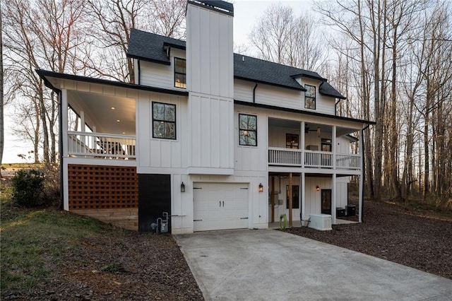 29 Highpoint Ridge Ct, Ellijay, GA 30536 - view of front facade with an attached garage, a shingled roof, concrete driveway, board and batten siding, and a chimney