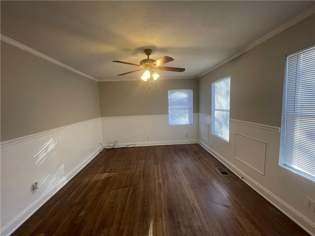 empty room with a textured ceiling, dark hardwood / wood-style floors, ceiling fan, and ornamental molding