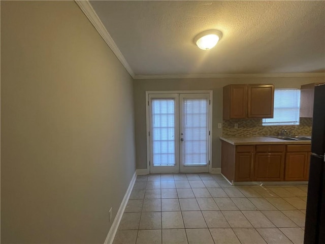 kitchen with a healthy amount of sunlight, light tile patterned flooring, french doors, and tasteful backsplash