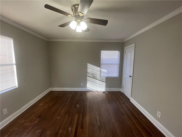 spare room featuring a wealth of natural light, ceiling fan, dark wood-type flooring, and ornamental molding