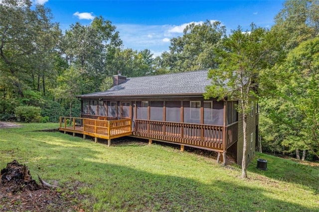 back of house with a sunroom, a deck, and a yard