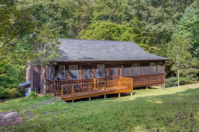 back of house featuring a wooden deck, a sunroom, and a yard