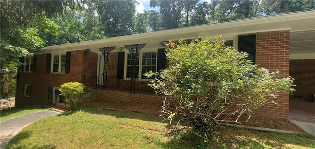 view of front of house with brick siding, a porch, and a front yard