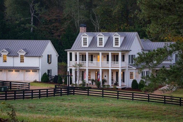 view of front of home with a front lawn, a balcony, a porch, and a garage