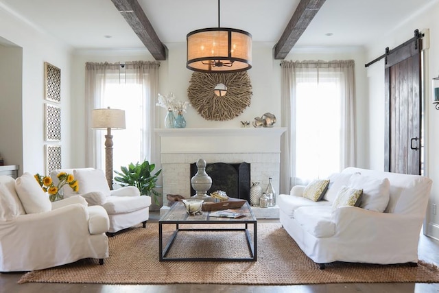 living room featuring a fireplace, a barn door, and beamed ceiling