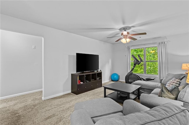 living area featuring a ceiling fan, baseboards, and carpet flooring