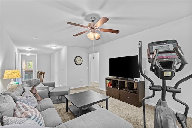 carpeted living room featuring ceiling fan and baseboards