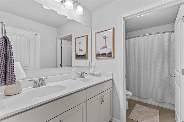 bathroom with double vanity, toilet, and tile patterned floors