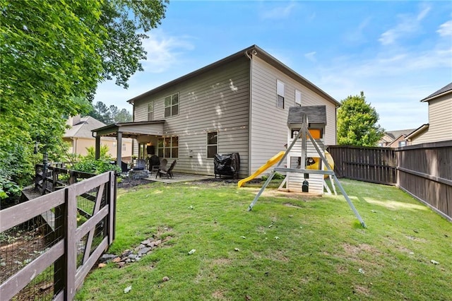 rear view of property featuring a playground and a patio