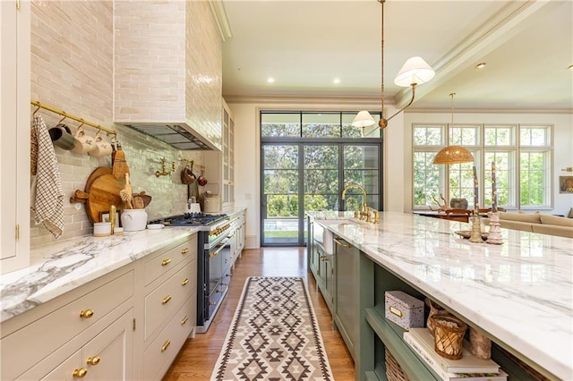 kitchen featuring a sink, ornamental molding, range with gas stovetop, and tasteful backsplash
