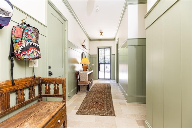 mudroom featuring stone tile floors, a decorative wall, and ornamental molding