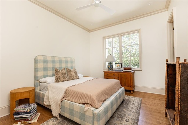 bedroom with ceiling fan, baseboards, ornamental molding, and wood finished floors