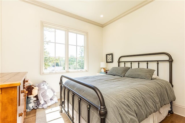 bedroom featuring baseboards, multiple windows, ornamental molding, and wood finished floors