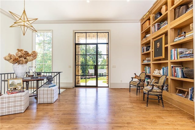 living area with crown molding, baseboards, and wood finished floors
