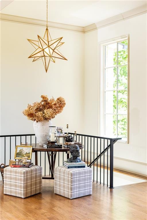 living area with crown molding, an upstairs landing, wood finished floors, and a wealth of natural light