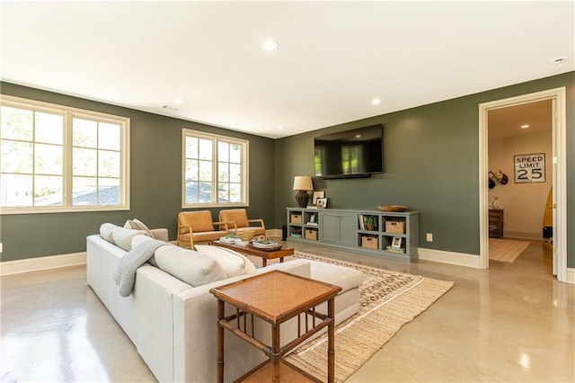 living area featuring concrete flooring, baseboards, and recessed lighting