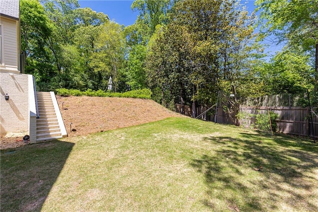view of yard with fence and stairway