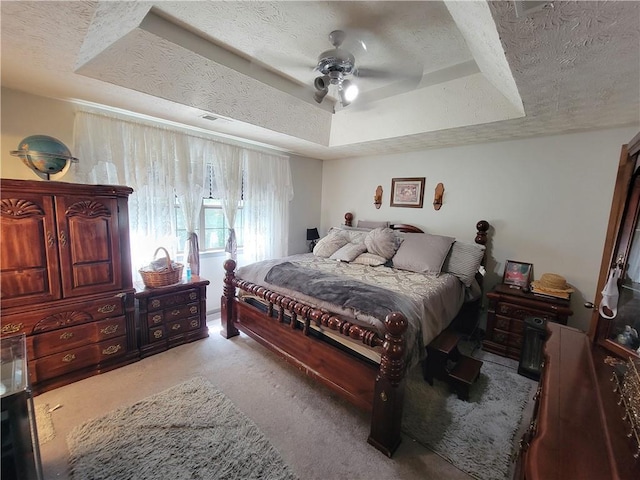 3723 Raiders Ridge Dr, Lithonia, GA 30038 - bedroom with a textured ceiling, carpet, a tray ceiling, and a ceiling fan