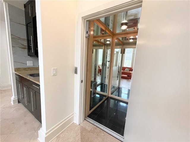 hallway with light tile patterned floors and sink