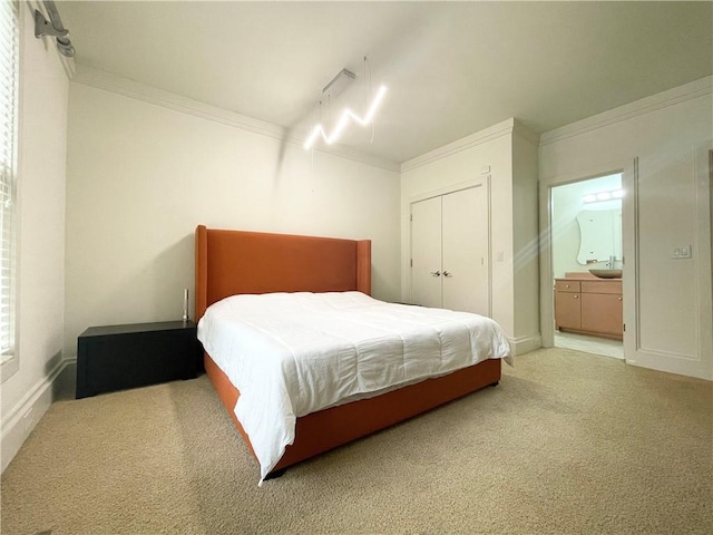 carpeted bedroom featuring ensuite bathroom and ornamental molding