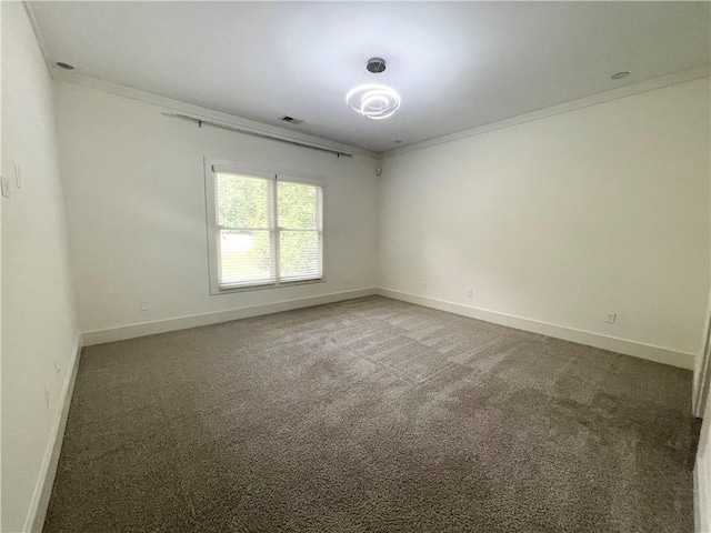 spare room with dark carpet and crown molding