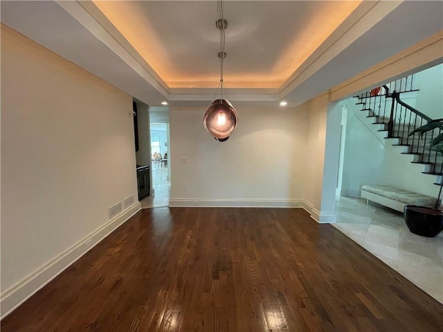 interior space featuring dark hardwood / wood-style flooring and a tray ceiling