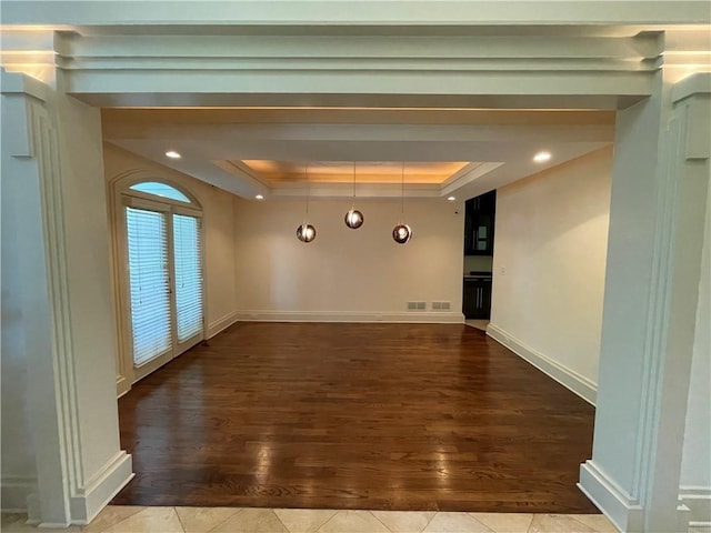 spare room featuring hardwood / wood-style flooring and a raised ceiling