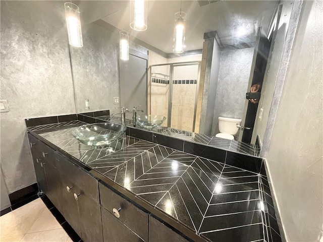 bathroom featuring toilet, vanity, tile patterned floors, and walk in shower