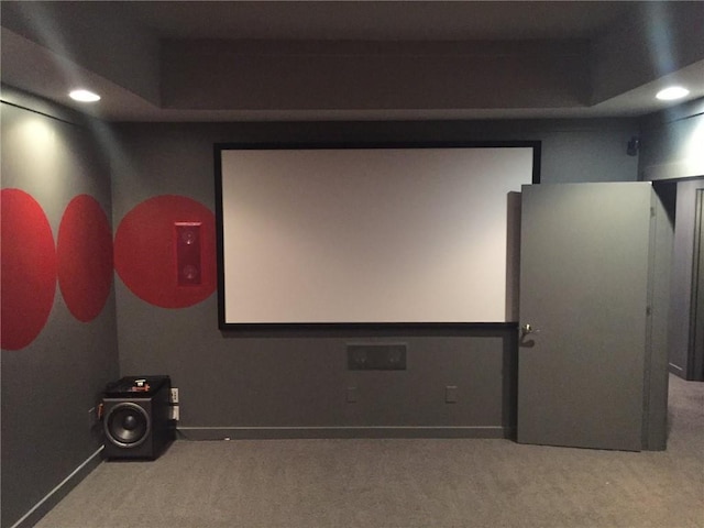 carpeted home theater featuring a raised ceiling