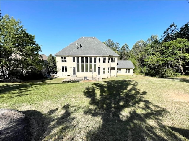 rear view of house featuring a yard and a patio area