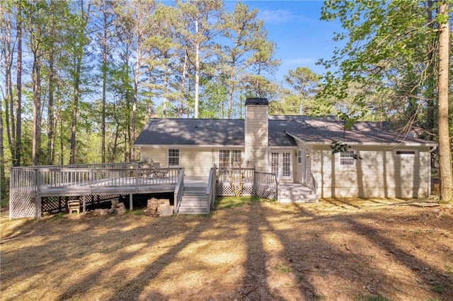 rear view of house featuring a deck and a chimney