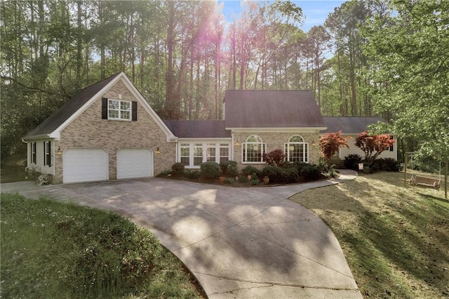 cape cod-style house featuring roof with shingles, driveway, and a garage