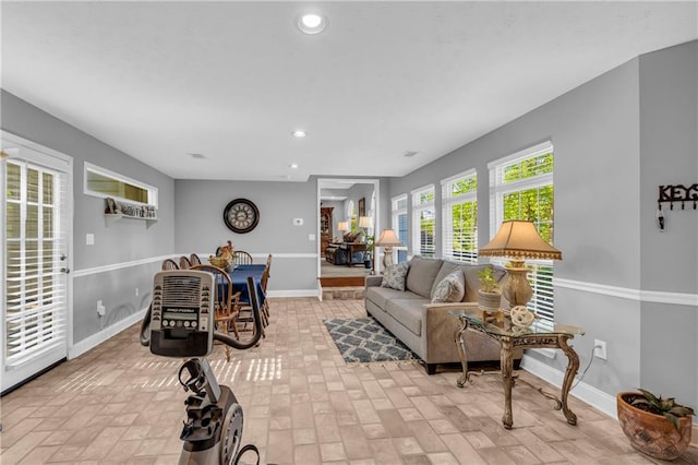 living area featuring recessed lighting, baseboards, and brick patterned floor