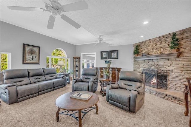 living room with ceiling fan, a textured ceiling, carpet flooring, and a fireplace