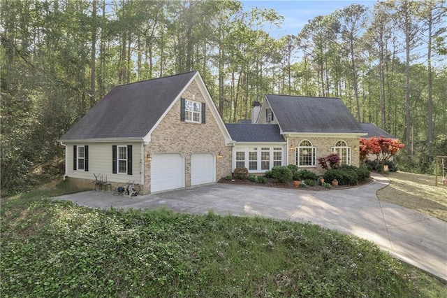 view of front of house featuring an attached garage, a shingled roof, and aphalt driveway