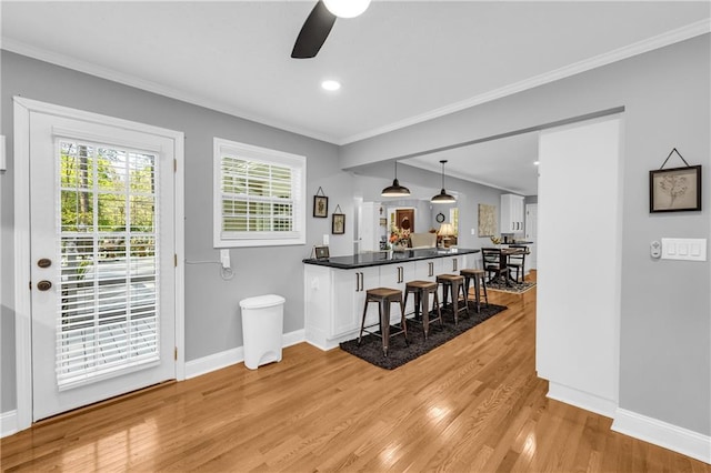 interior space with crown molding, ceiling fan, recessed lighting, light wood finished floors, and baseboards