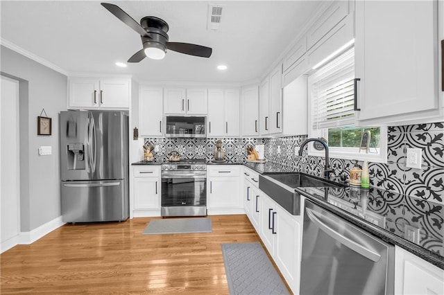 kitchen with visible vents, a sink, ceiling fan, dark countertops, and appliances with stainless steel finishes