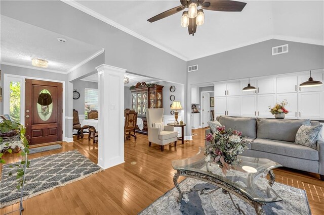 living room featuring light wood finished floors, decorative columns, a ceiling fan, and visible vents