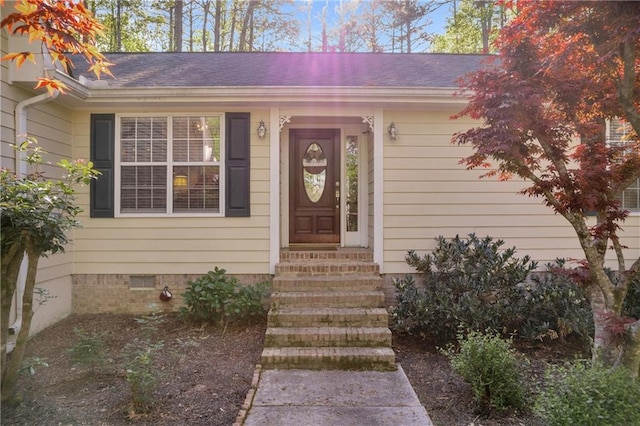 property entrance featuring crawl space and a shingled roof