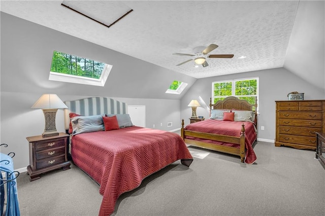 bedroom featuring vaulted ceiling with skylight, baseboards, and carpet