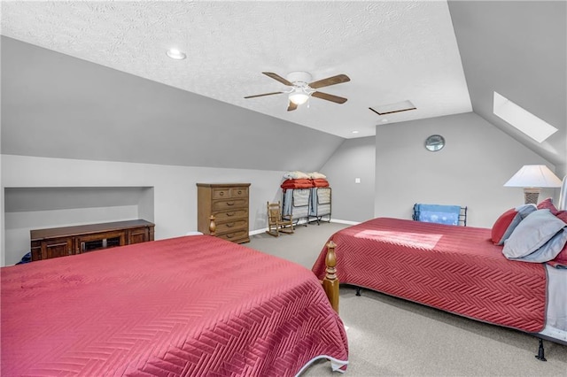 carpeted bedroom featuring a textured ceiling, a ceiling fan, attic access, and lofted ceiling