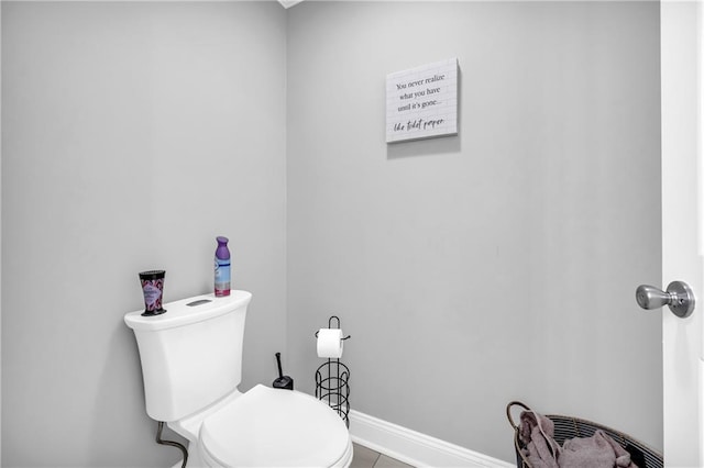 bathroom with toilet and baseboards