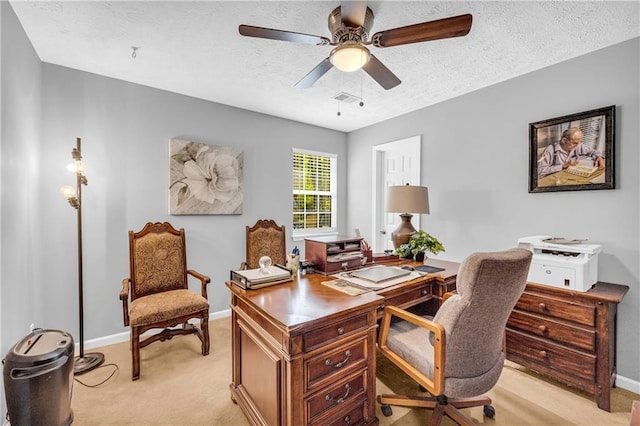 office with visible vents, baseboards, a ceiling fan, a textured ceiling, and light carpet